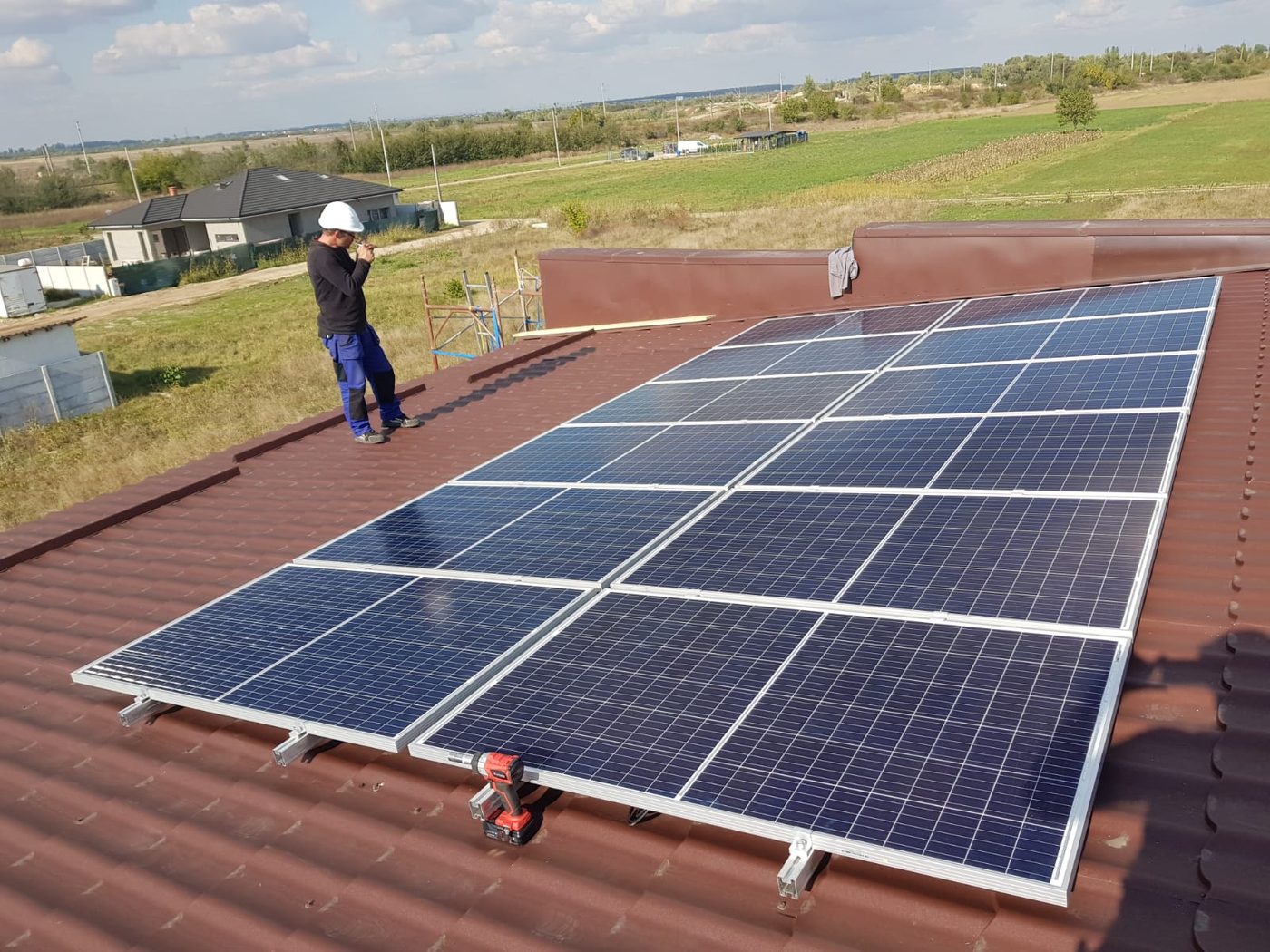 Tehnician la montajul unui sistem fotovoltaic pe acoperiș